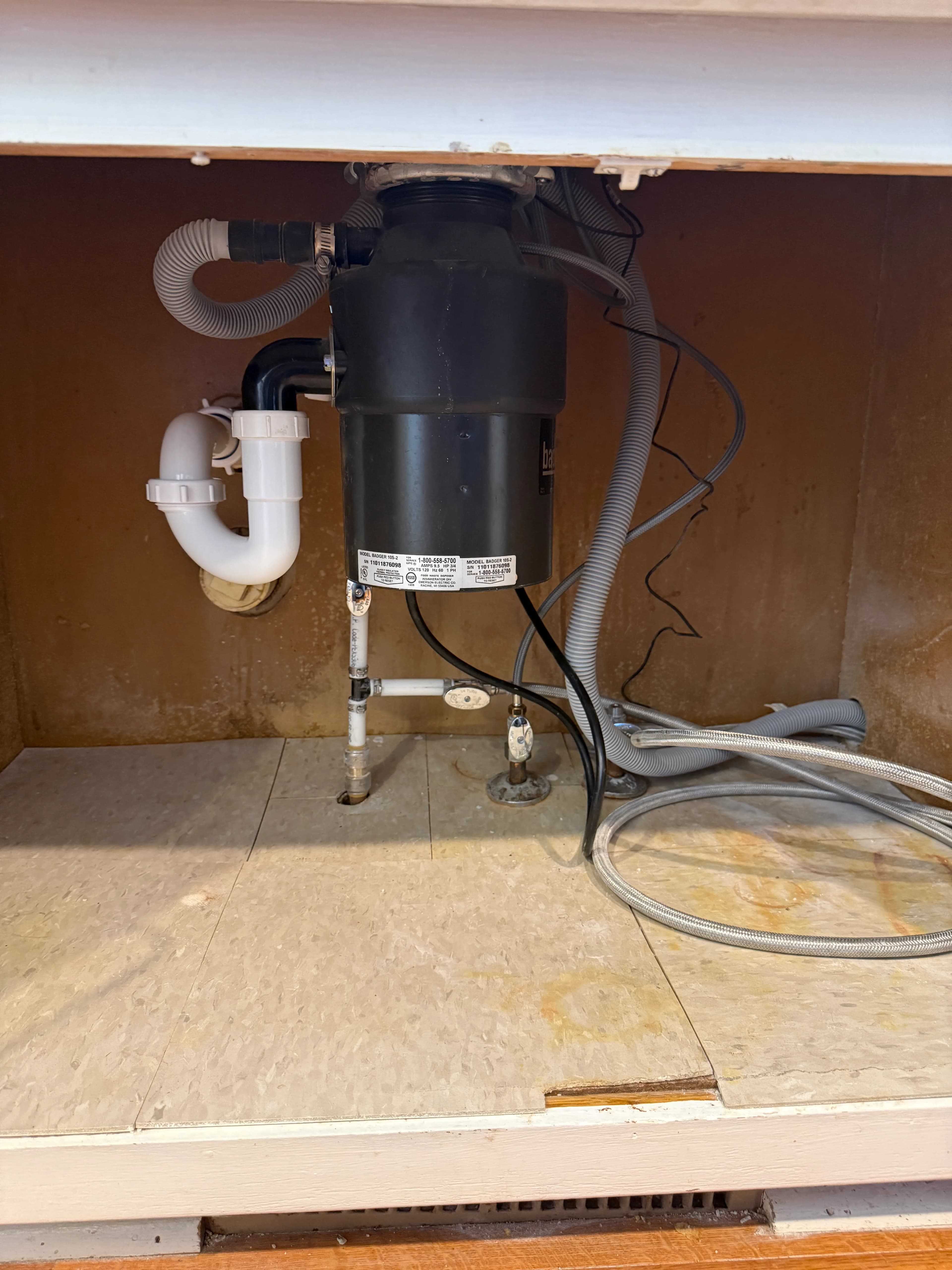 Supply and drain lines under a kitchen sink — a common place to find pinhole leaks and corrosion