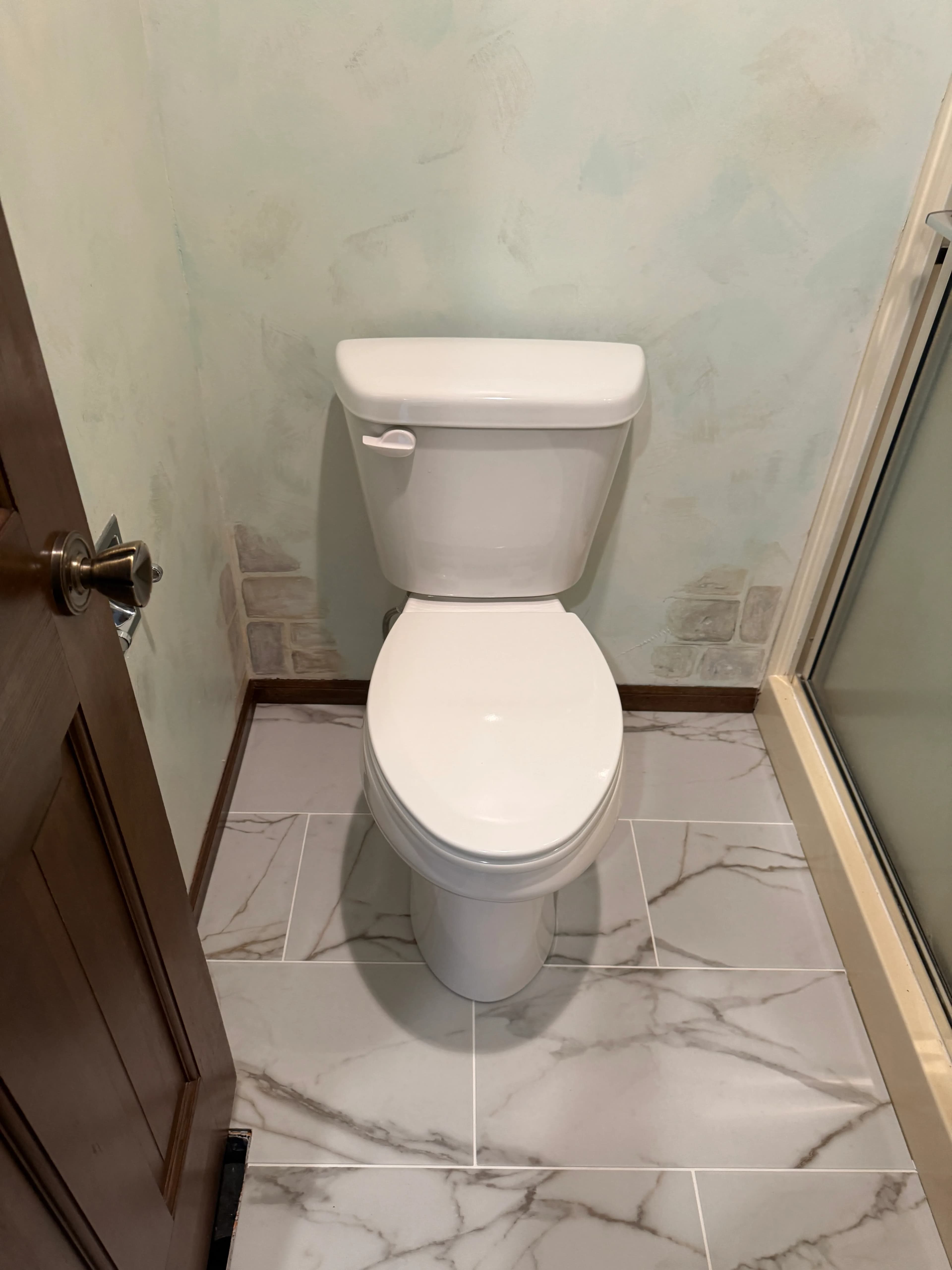 Toilet installed on marble bathroom flooring