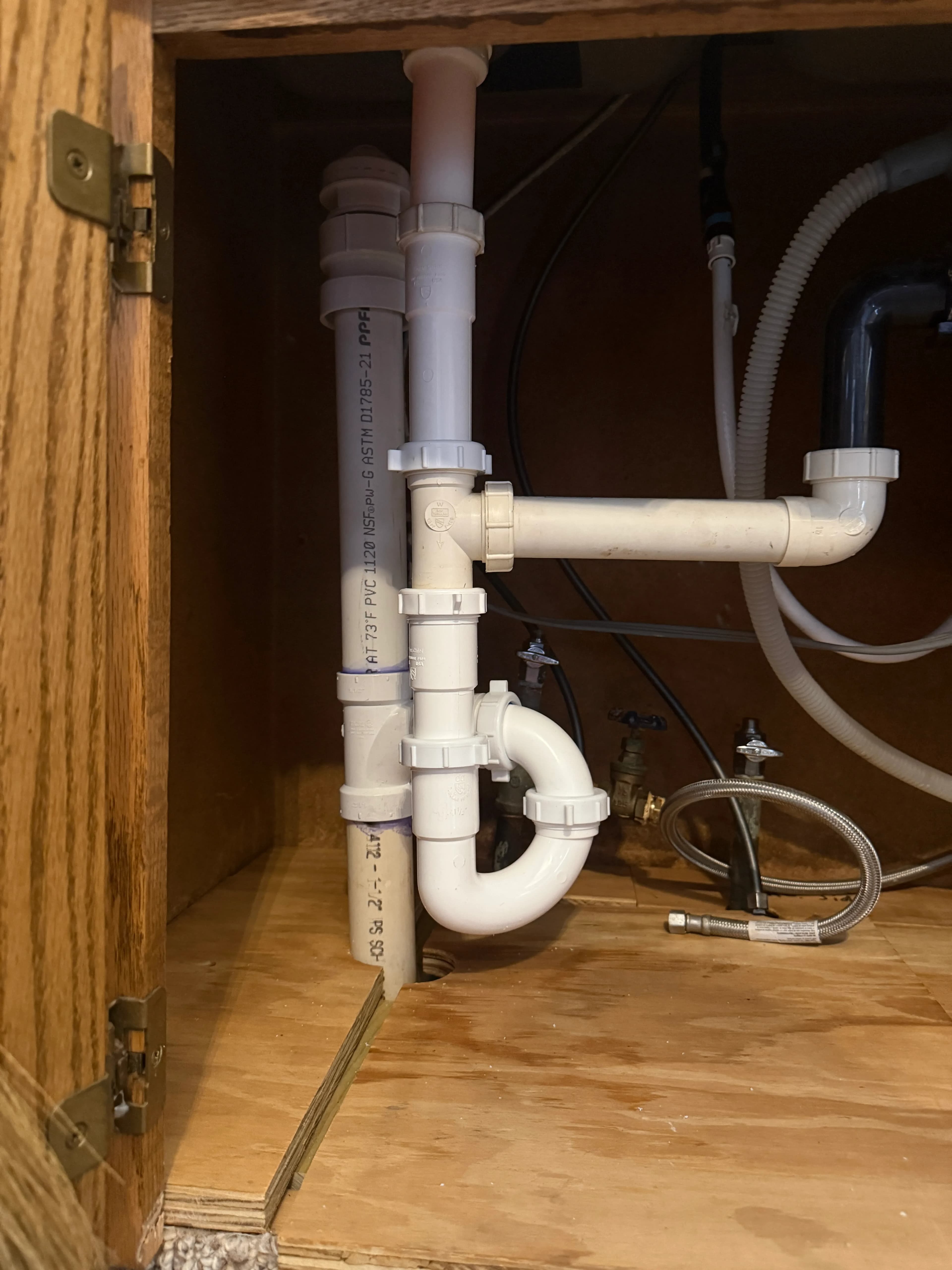 Under-sink P-trap and drain line during leak inspection