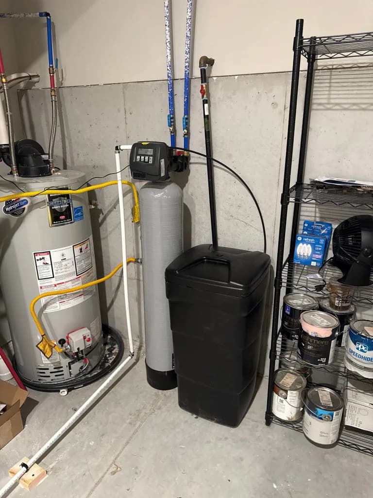 Tank water heater and water softener installed in a basement utility room